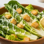 Gluten-free Caesar salad with romaine lettuce, Parmesan cheese, creamy dressing, and gluten-free croutons served in a rustic bowl.