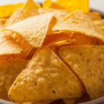 Crispy gluten-free nacho chips made from corn and quinoa, served as a healthy snack