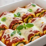 Low-cal zucchini lasagna rolls baked in marinara sauce with melted mozzarella and fresh basil.