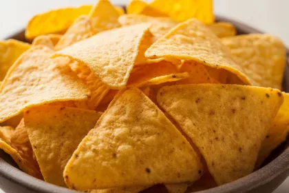 Crispy gluten-free nacho chips made from corn and quinoa, served as a healthy snack